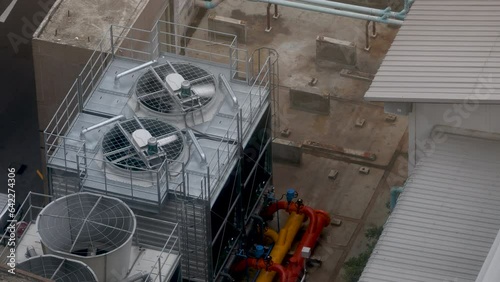 Cooling towers in data center building. Air conditioning cooling towers in front of building with fins to the front. Industrial cooling towers or air cooled water chillers with piping system.