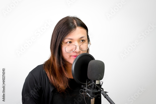 Beautiful asian woman (LGBTQ) is a singer. She enjoying sing a song or karaoke in music studio with microphone condenser and headphones for fun or voice creative photo