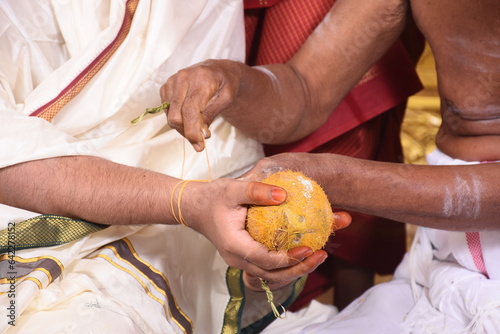 ritual of tamil brahmin wedding- kappukattu- tying a sacred thread on hand photo