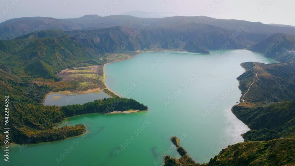 Aerial volcanic island lagoon in morning. Rippling turquoise water wash rocky Aerial volcanic island lagoon in morning. Rippling turquoise water wash rocky