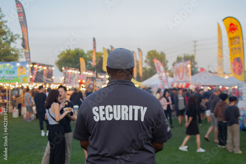 A security guard is controlling the traffic and parking situation at an Asian festival in Canada.
