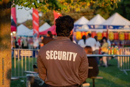 A security guard is controlling the traffic and parking situation at an Asian festival in Canada.