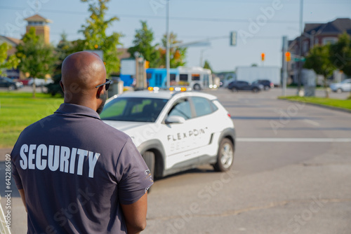 A security guard is controlling the traffic and parking situation at an Asian festival in Canada.