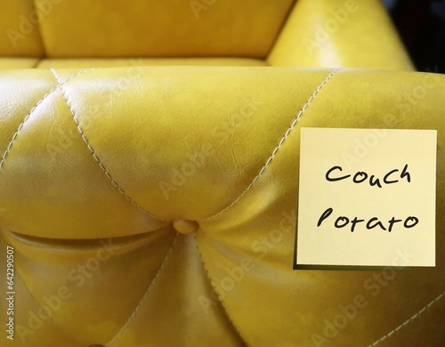 Yellow sofa with stick note written COUCH POTATO, refers to person who lives sedentary lifestyle, lazy and inactive person who watch TV and eats junk food all the time photo