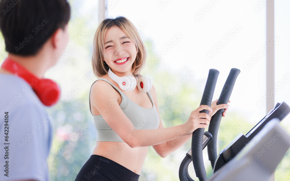 Asian young fit male female athlete jogger runner in sportswear sport bra legging wear wireless headphones smiling while exercise training on treadmill machine