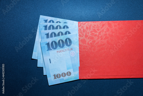 Red envelope and four thousand New Taiwan Dollars (4000 NTD). The concept of giving money, gifts, buying, lucky money and exchange. photo
