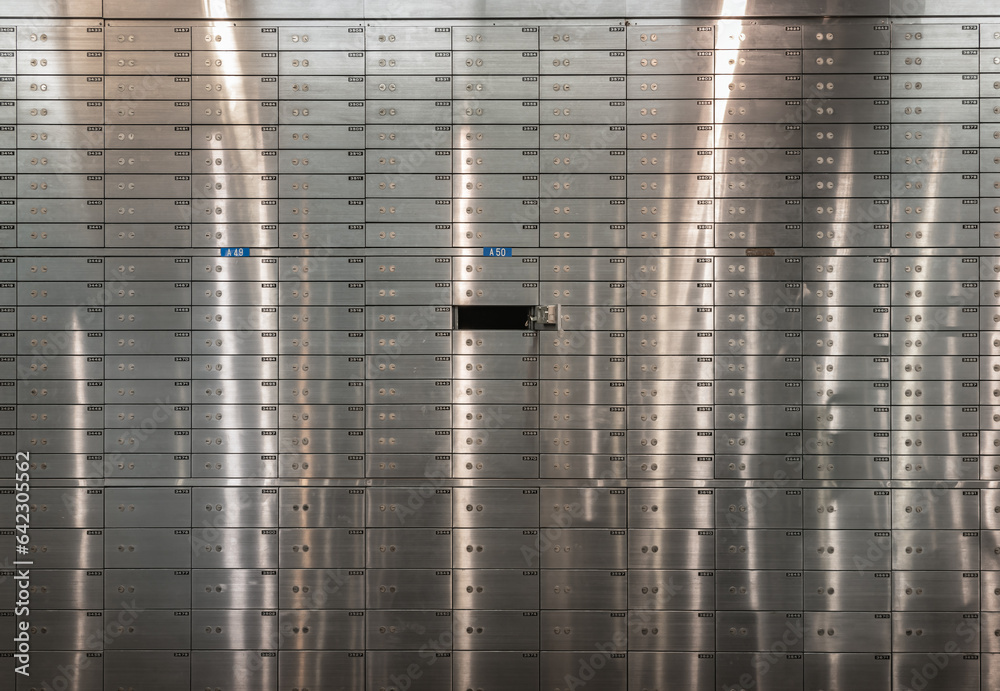 Safe deposit boxes inside bank vault with closed steel doors. Metal deposit lockers, Open deposit box with key, Space for text, Selective focus. - obrazy, fototapety, plakaty 