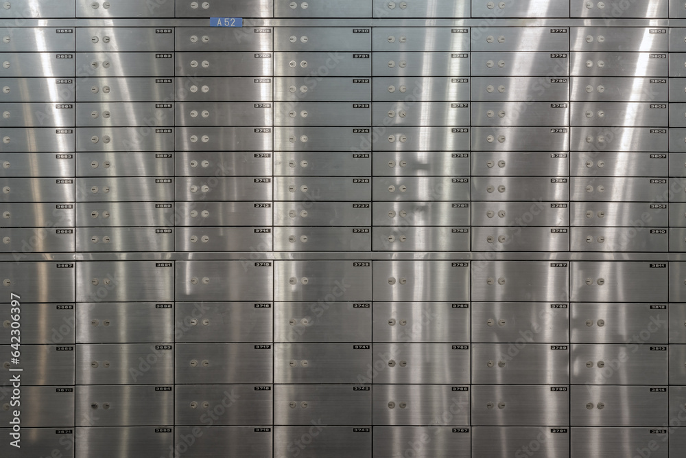 Safe deposit boxes inside bank vault with closed steel doors. Metal deposit lockers, Space for text, Selective focus.