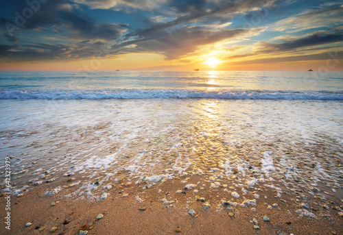 Fototapeta Naklejka Na Ścianę i Meble -  Sand and rocks on seashore at sunset