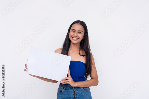 An idealistic young Filipino woman smiling while holding a blank white signage or placard. Isolated on a white background.