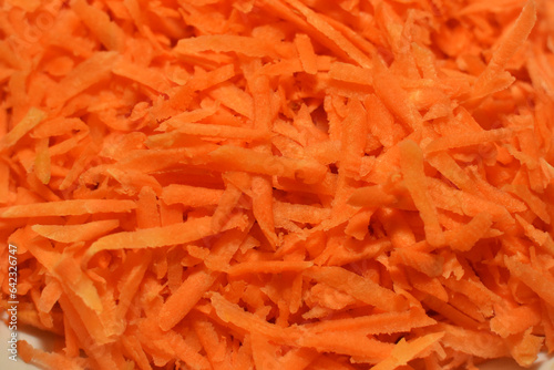 Background of fresh red grated carrots for cooking, close-up