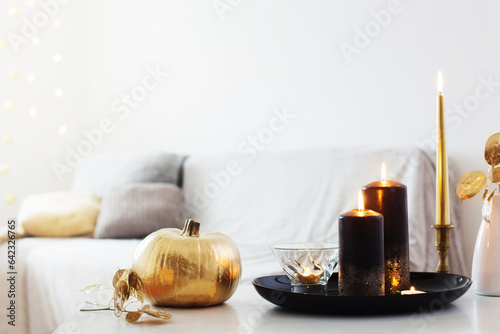 home decor with golden pumpkin and burning candles