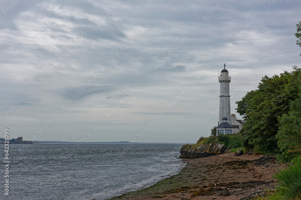 The West Lighthouse of the Tay Estuary situated near to the small Town of Tayport under heavy cloud between rain showers in July.