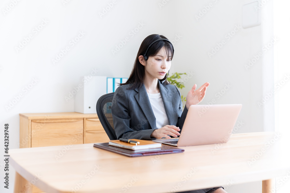 パソコンを使うスーツを着た日本人女性 パソコンを使うスーツを着た日本人女性