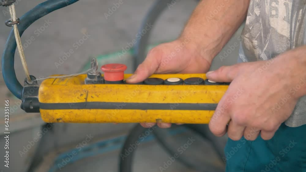 Male hand push remote control switch. Electrical control panel of the crane and other lifting equipment in engineer's hand