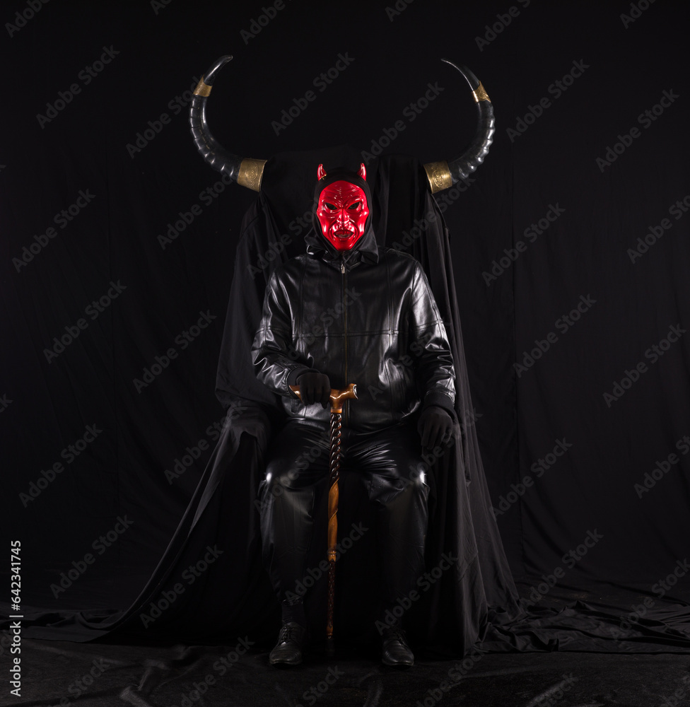 portrait of a male devil with horns on a black throne
