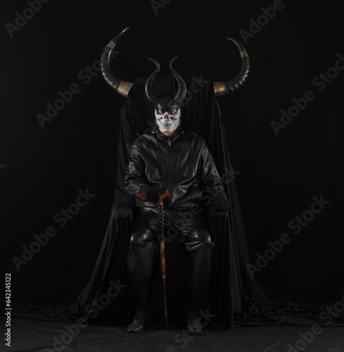 portrait of a male devil with horns on a black throne