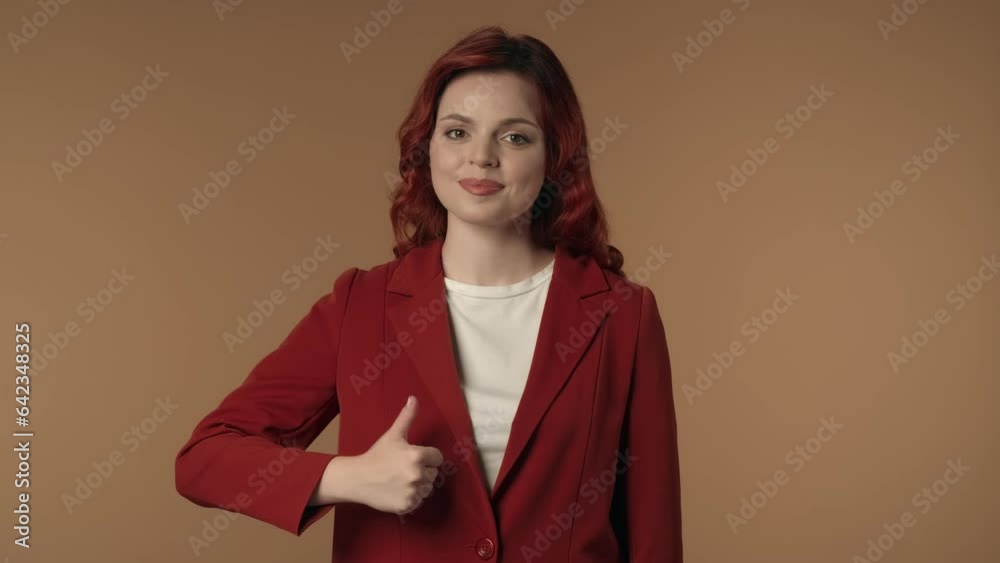 Medium isolated video of a satisfied, happy and active young woman giving a thumbs-up and smiling at the camera. Medium isolated video of a satisfied, happy and active young woman giving a thumbs-up and smiling at the camera.