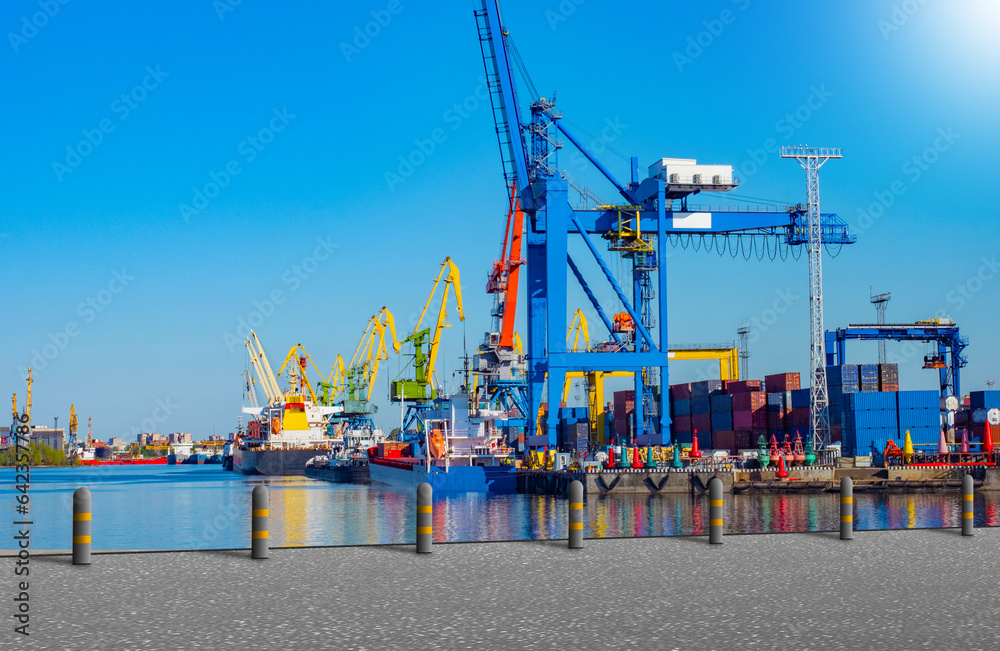 Shipyard for cargo ships. Sea port on sunny day. Cranes on shore of shipyard. Place for unloading ships. View of harbor with ships. Shipyard for maritime logistics. Cargo sea port.