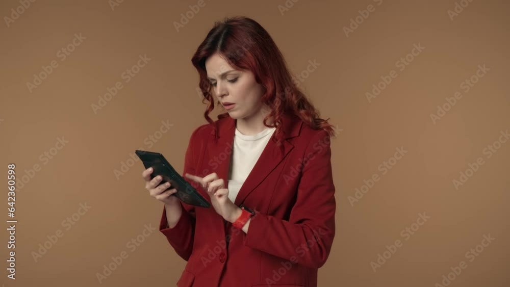 Medium isolated video of a joyful and relaxed young woman thinking, then counting something using calculator in her hand. Medium isolated video of a joyful and relaxed young woman thinking, then counting something using calculator in her hand.