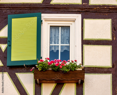 Schmuckes Fenster mit Fensterladen in historischer Fachwerkfassade