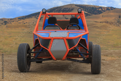 Buggy on the ground against the backdrop of a mountain landscape