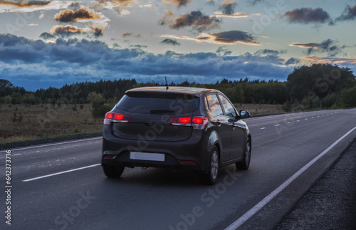 Crossover driving on a country road at sunset © Yuri Bizgaimer