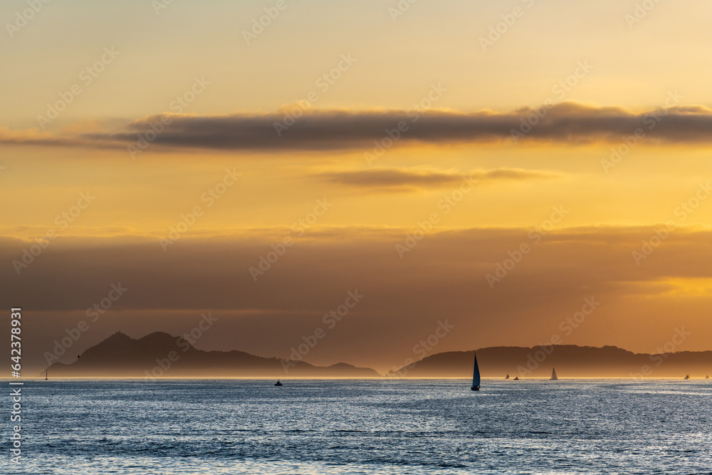 Boats sailing in the Ria de Vigo in Galicia at sunset, with the Cies Islands in the background.