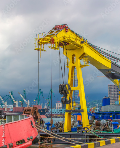 yellow sea lift against the background of cargo ships and a sky with clouds