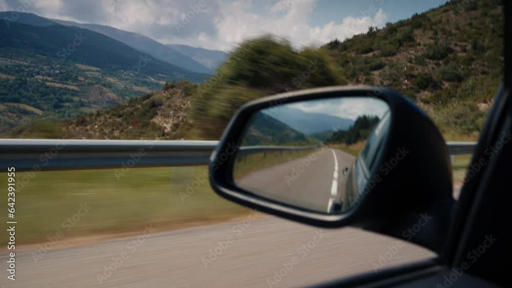 Vacation road trip vehicle rearview mirror on mountain road in movement