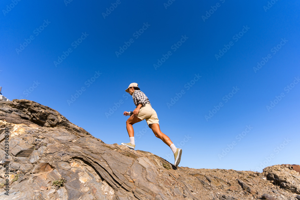 tourist girl with a backpack on her back climbs the mountain in summer tourist girl with a backpack on her back climbs the mountain in summer