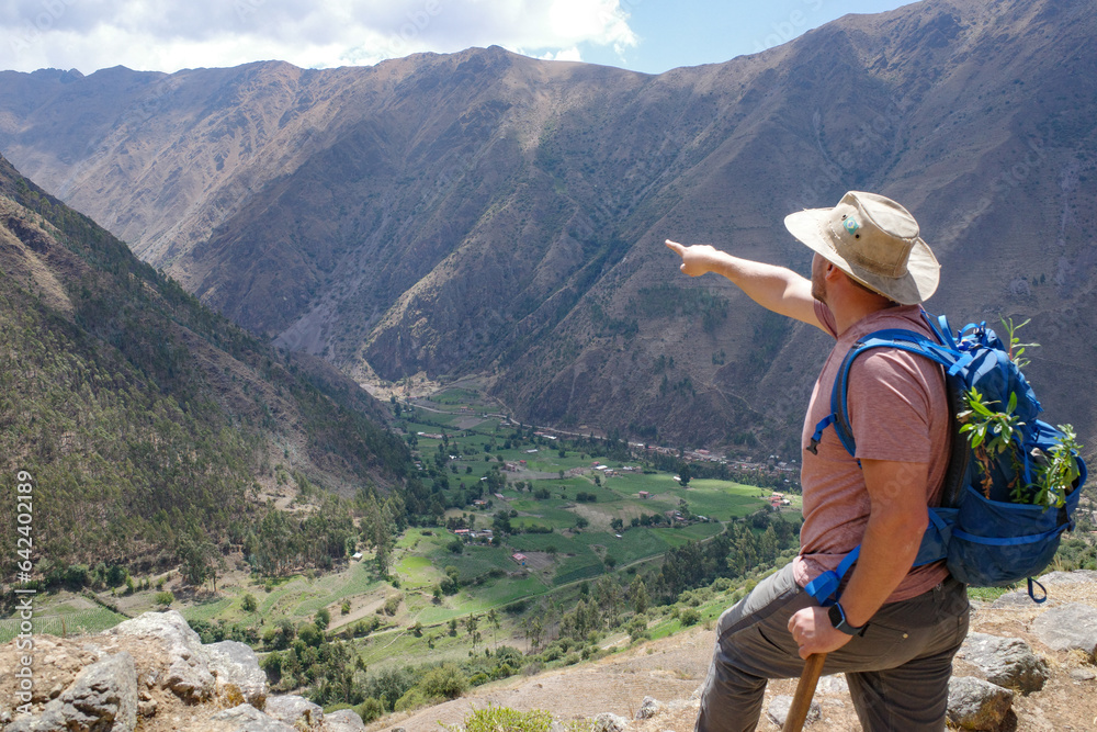 Cusco, Peru - Dec 3, 2022: A hiker overlooks the Sacred Valley from the Inca ruins of Pumamarca