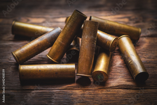 Bunch of old brass gun shells wooden table background close up. Hunting concept background.