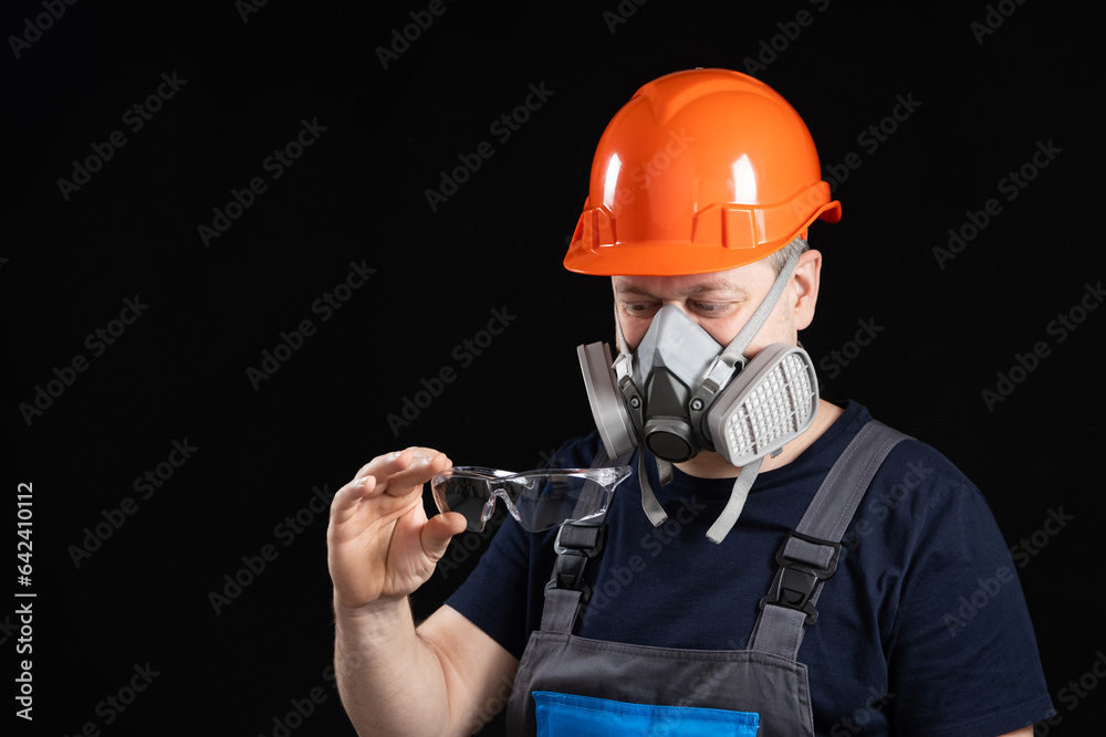A man wearing a helmet, respirator and goggles on a black background A man wearing a helmet, respirator and goggles on a black background