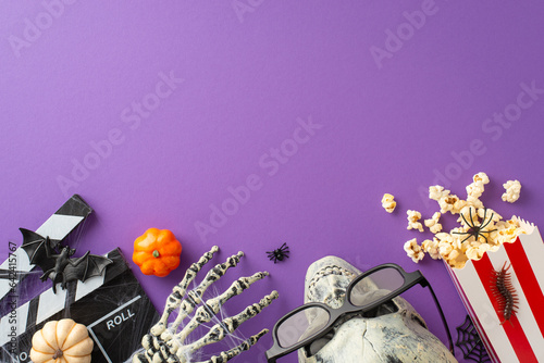 Embark on a journey into the realm of Halloween entertainment through above view of cinema popcorn paired with spooky decorations on isolated purple backdrop  perfectly suited for your advertising