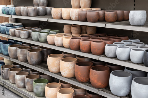 Several flower pots in different sizes and colors in a row next to each other.