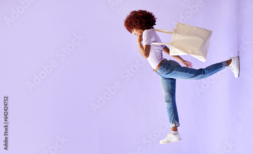 Fashion, shopping and a woman walking on mockup in studio on a purple background for advertising. Retail, commerce and orientation with a young customer carrying bags on banner space for marketing