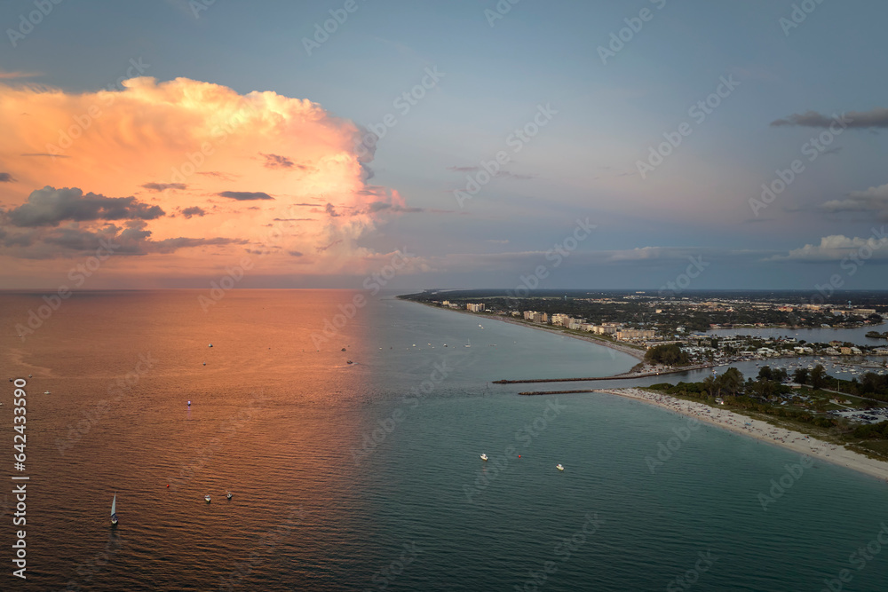 Aerial view of sea shore near Venice, Florida with white yachts at sunset floating on sea waves. North and South Jetty on Nokomis beach. Motor boat recreation on ocean surface