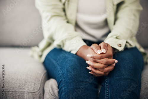 Anxiety, hands and woman on a sofa with stress, fear or worry for mental health or domestic abuse in her home. Psychology, zoom and female with depression, bipolar or scared of gender based violence photo
