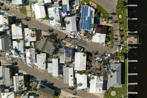 Property damage from strong hurricane winds. Mobile homes in Florida residential area with destroyed rooftops. Consequences of natural disaster photo