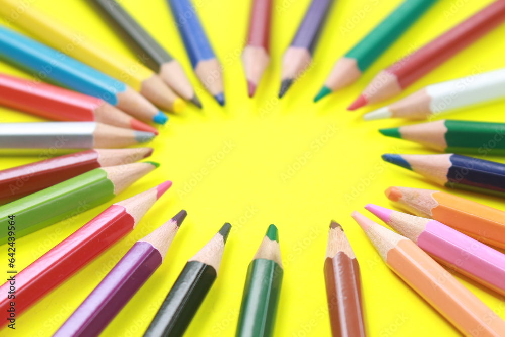 Wooden colored pencil with circular pattern isolated on yellow background. Wooden colored pencil with circular pattern isolated on yellow background.