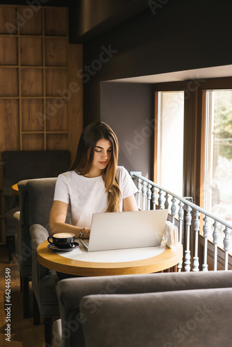 Woman specialist targetologist works at a laptop in a coffee shop. Concept of marketing and targeting photo