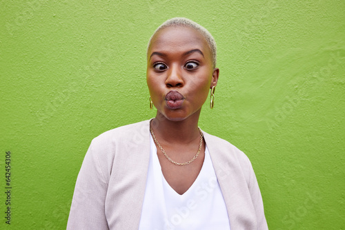 Happy, silly and young black woman by a green wall with trendy, classy and elegant jewelry and outfit. Happiness, goofy and African female model with positive and confident attitude with fashion.