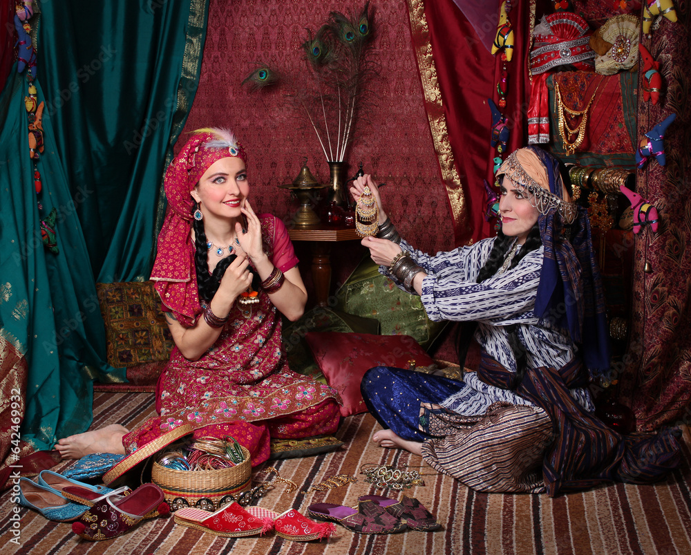 two women in old Asian traditional outfits are shopping in an old oriental shop. oriental bazaar, silk road