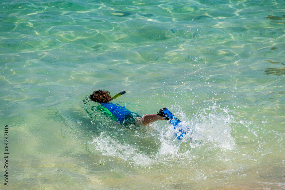 A kid snorkelling at Sundays Beach Club, Bali, Indonesia
