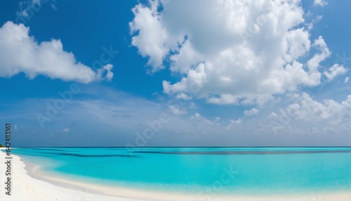 Sandy beach with white sand and rolling calm wave of turquoise ocean on sunny day  white clouds in blue sky background