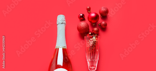 Beautiful New Year composition with bottle of champagne, glass and baubles on red background