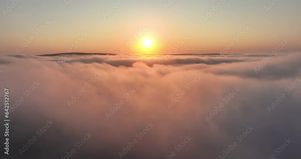 Flying over low hanging clouds at sunrise