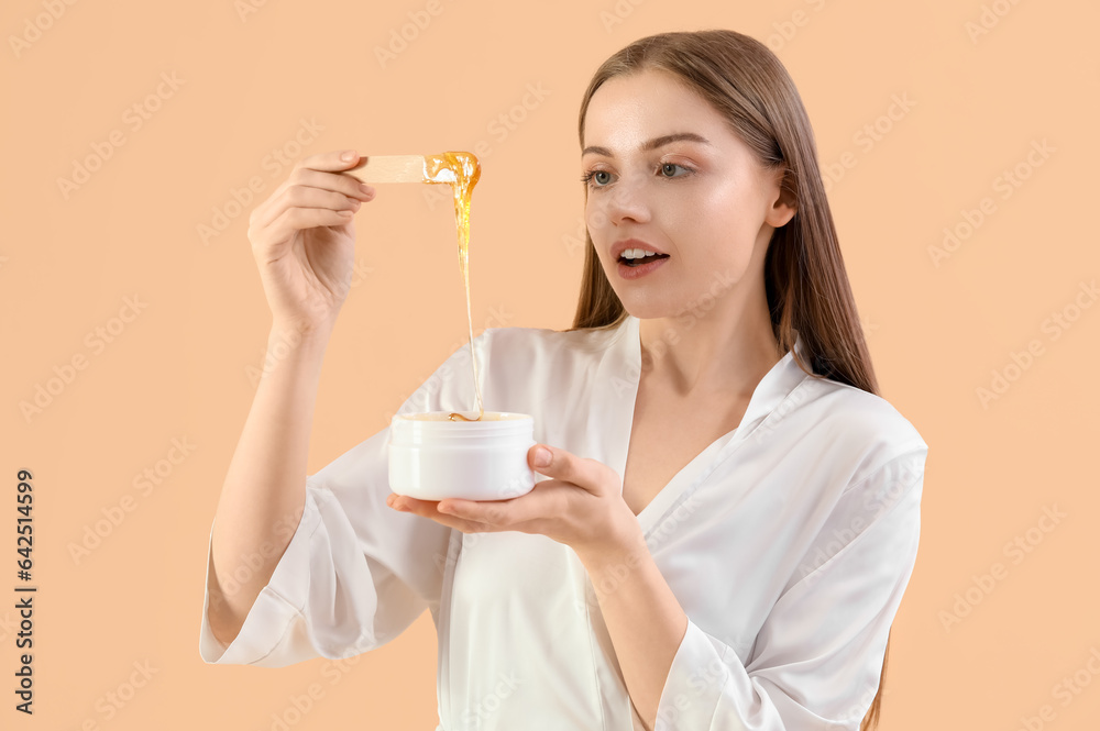 Pretty young woman with sugaring paste on beige background Pretty young woman with sugaring paste on beige background