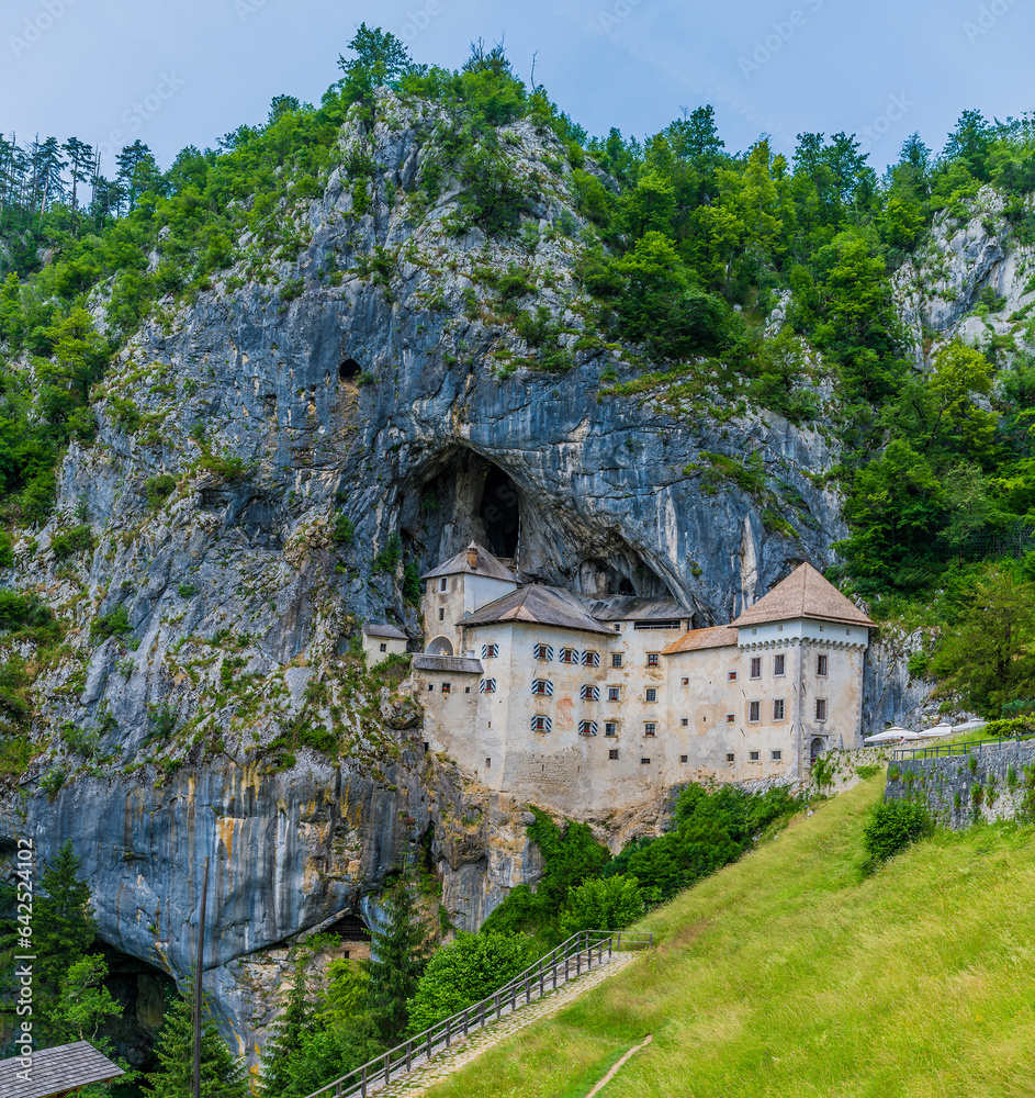 A view of the medieval castle built into the cliff face at Predjama, Slovenia in summertime
